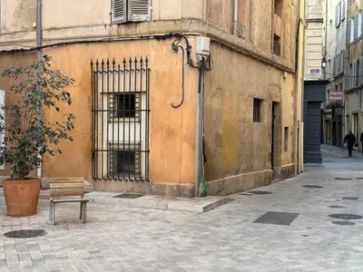 a bench in front of a building with a window at Chic et Cosy, Hyper centre in Aix-en-Provence
