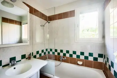 a bathroom with a sink and a tub and a mirror at Village Pont Royal en Provence - maeva Home - Maison climatisée 4 pièces 6 personnes - Sélection - super Home MAE-0411 in Mallemort
