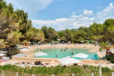 a group of people in a swimming pool with umbrellas at Village Pont Royal en Provence - maeva Home - Maison climatisée 4 pièces 6 personnes - Sélection - super Home MAE-0411 in Mallemort