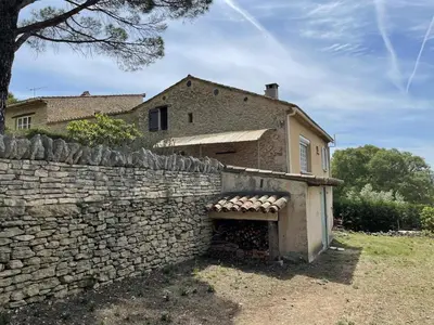an old stone wall next to a house at Lubéron Gîte Chaleureux 100 m2 piscine jardin in Saumane-de-Vaucluse