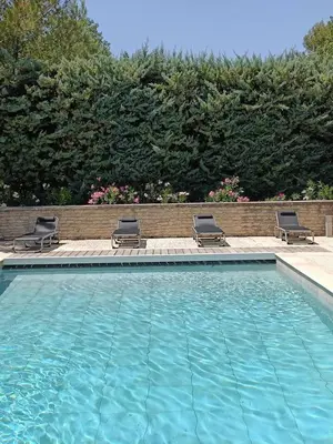 a swimming pool with two lounge chairs at Air-conditioned Stylish Provence Villa in Oppède