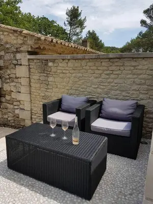 a patio with two chairs and a table with wine glasses at Air-conditioned Stylish Provence Villa in Oppède
