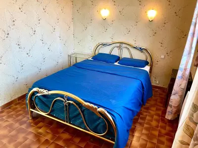 a bed with blue sheets and blue pillows in a room at Grand Appartement Provençal in Manosque
