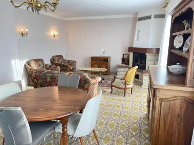 a living room with a wooden table and chairs at Grand Appartement Provençal in Manosque