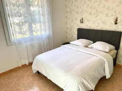 a bedroom with a bed with white sheets and a window at Grand Appartement Provençal in Manosque