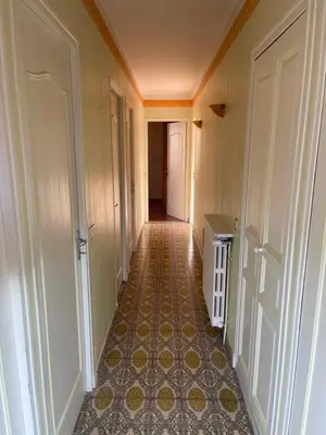 an empty hallway with a tile floor and white doors at Grand Appartement Provençal in Manosque