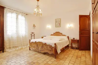 a bedroom with a bed and a chandelier at MAISON de CHARME in Cavaillon