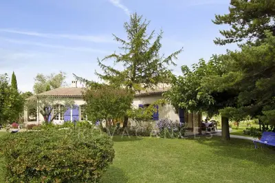 a house with a blue bench in a yard at MAISON de CHARME in Cavaillon