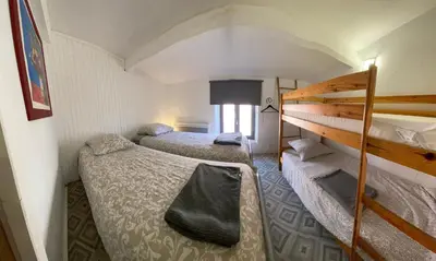a room with two beds and a bunk bed at La Roselière in Mérindol