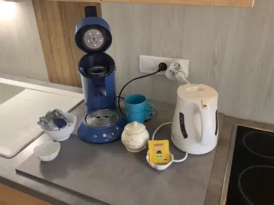a kitchen counter with a coffee maker and other appliances at La Roselière in Mérindol