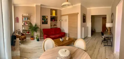 a living room with a red couch and a table at Appartement cosy lumineux et calme in Apt