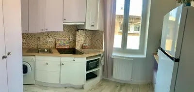a kitchen with white cabinets and a sink and a window at Appartement cosy lumineux et calme in Apt