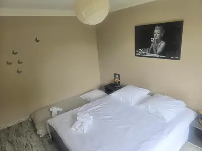 a bedroom with a white bed with a picture on the wall at Maison Climatisée, Jardin, Piscine, 7 pers in Salon-de-Provence