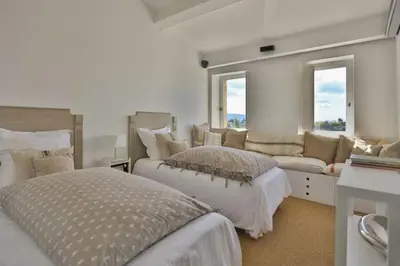 a white bedroom with two beds and a couch at Character House In The Heart Of Gordes in Gordes