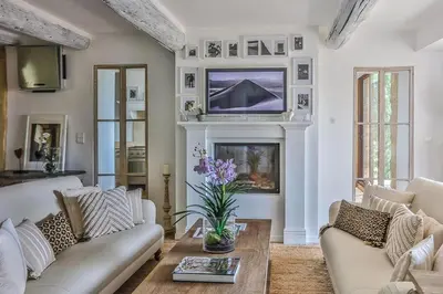 a living room with a couch and a tv on a fireplace at Character House In The Heart Of Gordes in Gordes