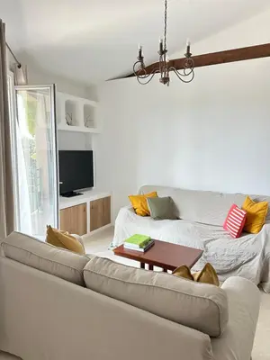a living room with a couch and a tv at Le Grand Bouteillan in Pierrevert