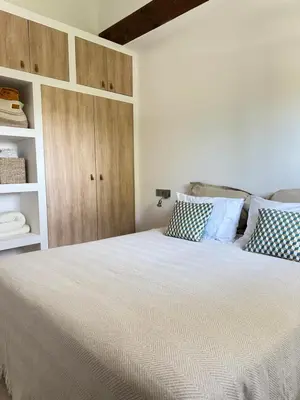 a bedroom with a large bed with blue and white pillows at Le Grand Bouteillan in Pierrevert