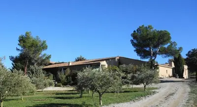 an old house with a dirt road in front of it at Le Grand Bouteillan in Pierrevert
