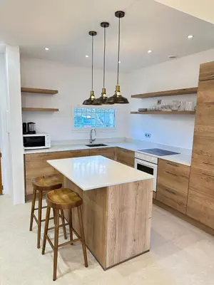 a kitchen with a wooden island with stools in it at Le Grand Bouteillan in Pierrevert
