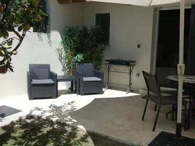 a patio with chairs and a table and a table at La Sarriette Provençale in Caumont-sur-Durance