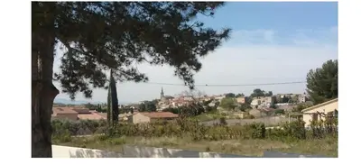 a view of a city with a tree at La Sarriette Provençale in Caumont-sur-Durance