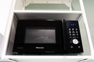 a microwave oven sitting inside of a white cabinet at Cocon T2 dans le centre d'Aix in Aix-en-Provence