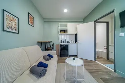a living room with a couch and a table at Studio raffiné - Aix hypercentre in Aix-en-Provence