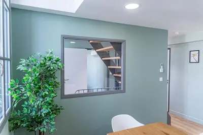 a mirror on a wall with a table and a plant at T4 d'exception à Aix in Aix-en-Provence