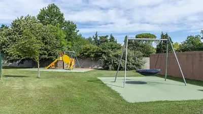 a playground with a swing set in a yard at Casa Luma in Saint-Saturnin-les-Avignon