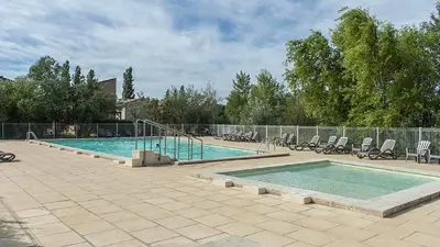 a large swimming pool with chairs and a fence at Casa Luma in Saint-Saturnin-les-Avignon