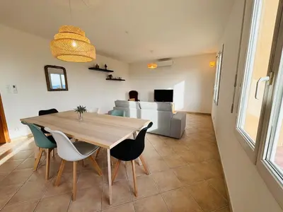 a dining table and chairs in a living room at Villa dans le Luberon in Saint-Saturnin-les-Apt