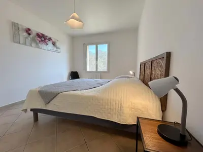 a bedroom with a bed and a lamp on a table at Villa dans le Luberon in Saint-Saturnin-les-Apt