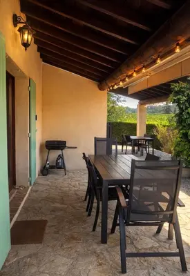 a patio with a table and chairs and a grill at Maison du Ventoux in Mormoiron
