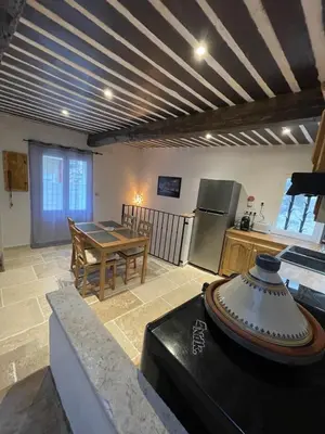 a kitchen and a dining room with a table and a kitchen at Maison de charme in Apt