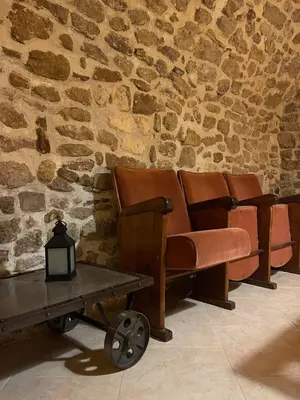 a row of brown leather chairs against a stone wall at Maison de charme in Apt