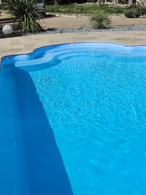a large blue swimming pool with blue water at Chez Cathy in Pernes-les-Fontaines