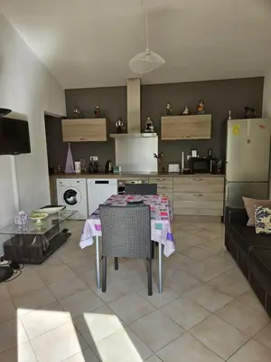 a living room with a table and a kitchen at Chez Cathy in Pernes-les-Fontaines