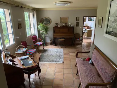 a living room with a couch and a piano at Le Mas St Pierre in Aix-en-Provence