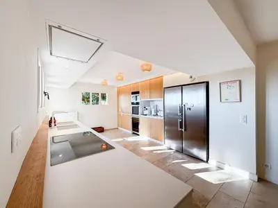 a large kitchen with a stainless steel refrigerator at Mas des Collines in Saint-Hippolyte-le-Graveyron