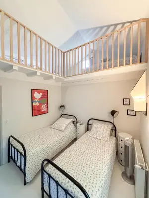 two beds in a room with a staircase at Mas des Collines in Saint-Hippolyte-le-Graveyron