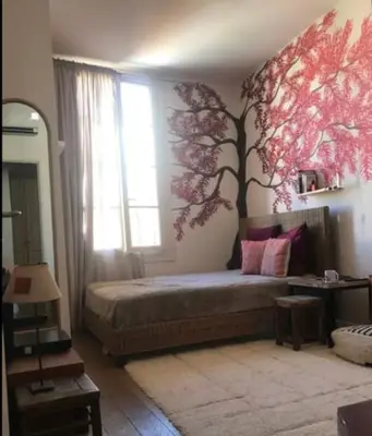 a bedroom with a bed with a tree on the wall at 100m2 beautiful appartment in Aix City Center in Aix-en-Provence