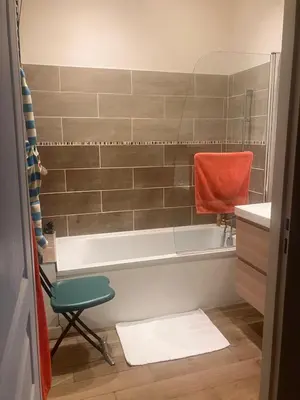 a bathroom with a tub and a chair in it at 100m2 beautiful appartment in Aix City Center in Aix-en-Provence