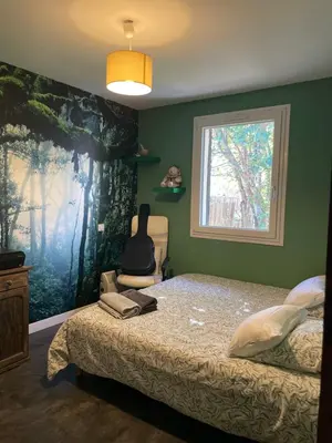 a bedroom with a bed with a large painting on the wall at Zen house with a view in Manosque
