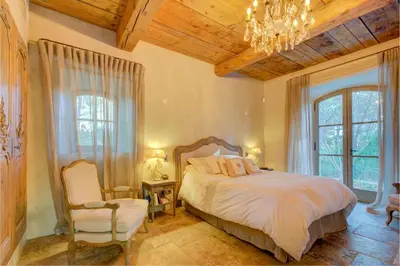 a bedroom with a bed and a chandelier at MAS DES CIGALES Lambesc in Lambesc