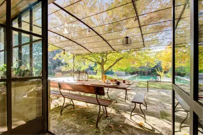 a screened in porch with a bench and a table at MAS DES CIGALES Lambesc in Lambesc
