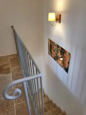 a staircase with a metal rail and a picture on the wall at Villa Doce Lar in Lioux