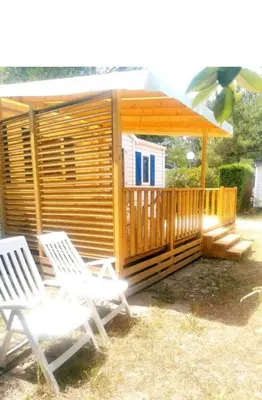 a cabin with two chairs and a gazebo at Comme Chez Vous Au Camping Des Iscles in La Roque-dʼAnthéron