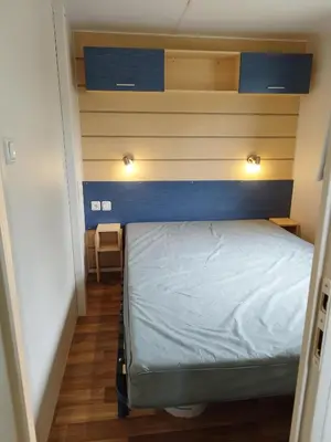 a small bedroom with a bed and two lights above it at Comme Chez Vous Au Camping Des Iscles in La Roque-dʼAnthéron