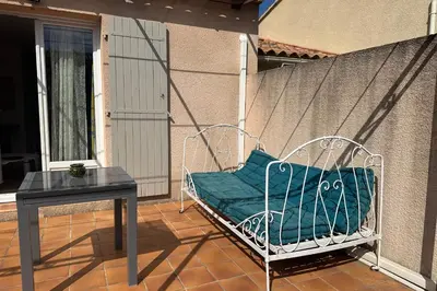 a hammock on a balcony with a table at At Tinou's spacious quiet house with garden for 2 people in LʼIsle-sur-la-Sorgue