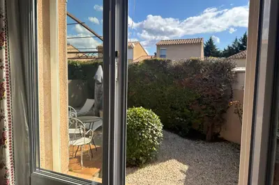 a view of a patio through a sliding glass door at At Tinou's spacious quiet house with garden for 2 people in LʼIsle-sur-la-Sorgue